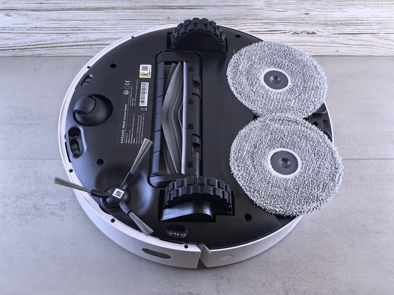 Detailed view of a robotic vacuum cleaner's underside showing brushes and wheels