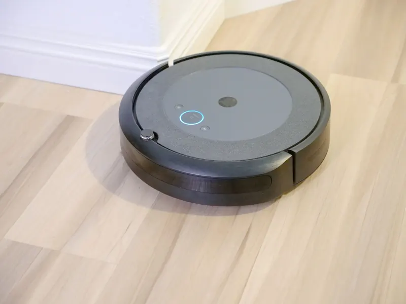 A sleek, modern robotic vacuum cleaner efficiently operating on a hardwood floor